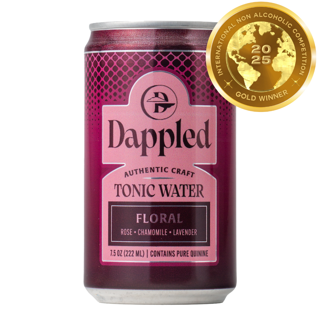 Bottle of handcrafted Floral Tonic Water with floral decorations and citrus garnish