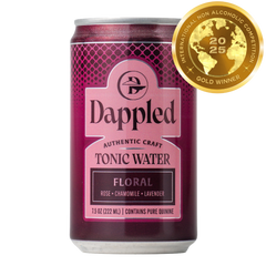 Bottle of handcrafted Floral Tonic Water with floral decorations and citrus garnish