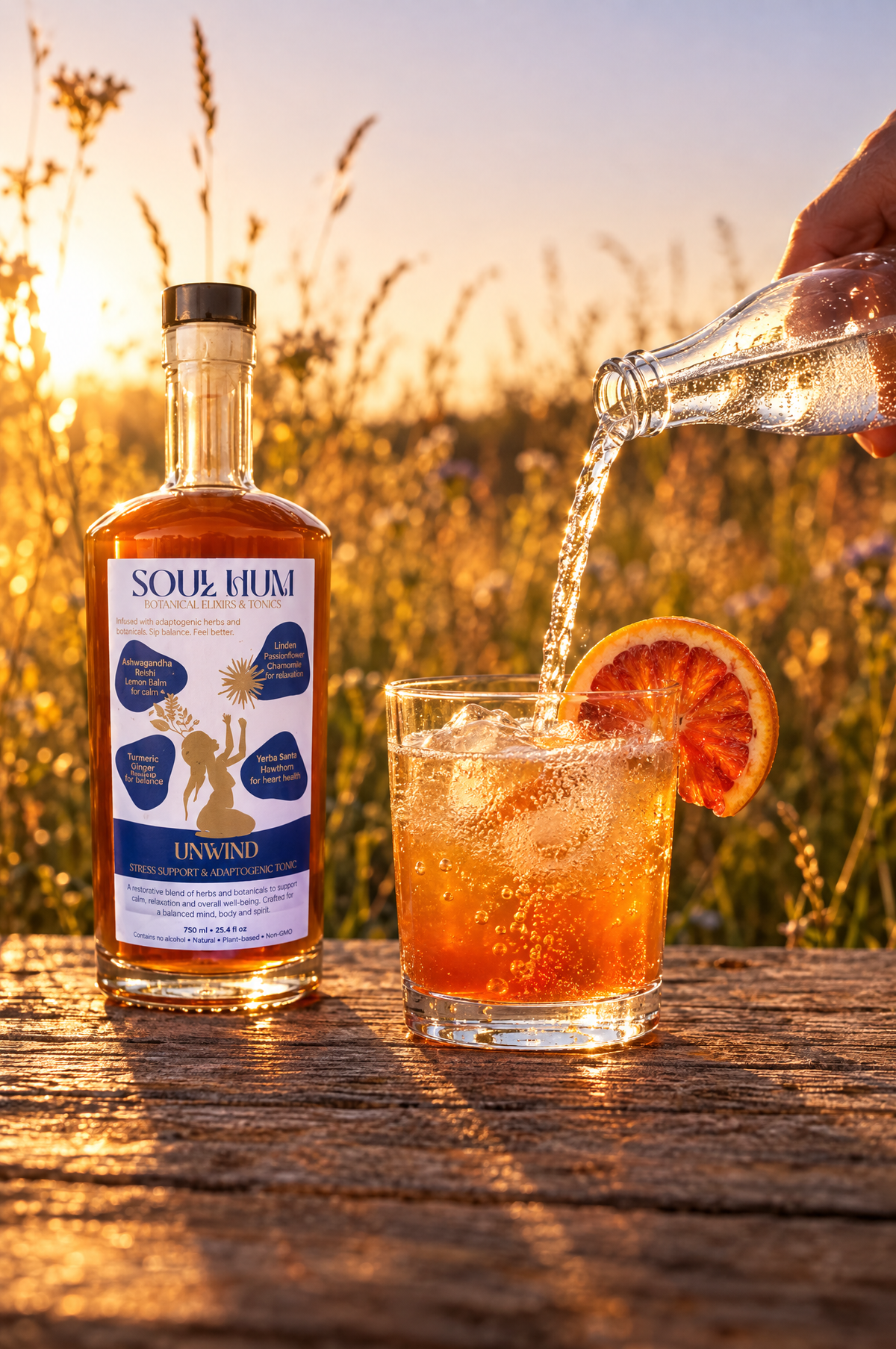 Topping a glass of Soul Hum Unwind elixir over ice with sparkling water, blood orange wheel on the rim