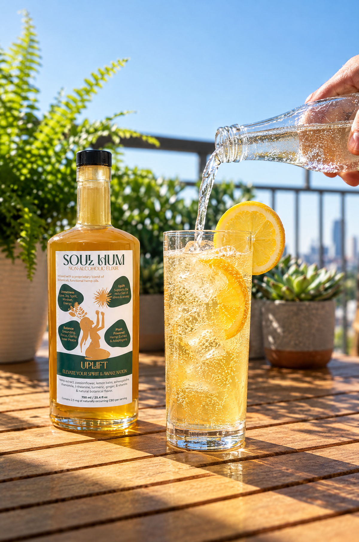 Topping a highball of Soul Hum Uplift elixir over ice with sparkling water, lemon wheel on the rim